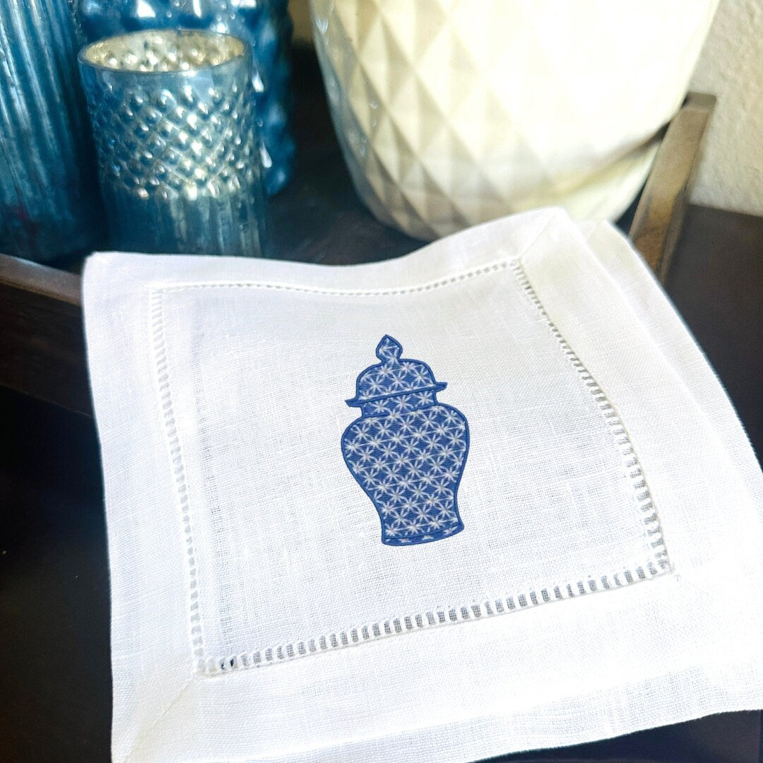 White napkin with blue decorative design on a dark surface