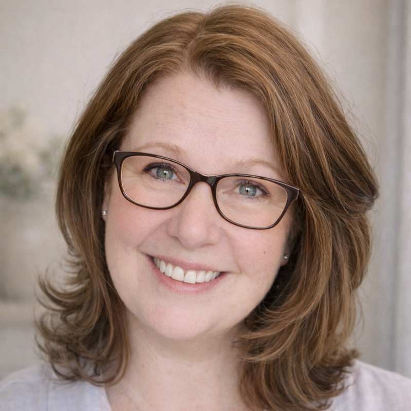 Woman with glasses and a light shirt in a professional setting