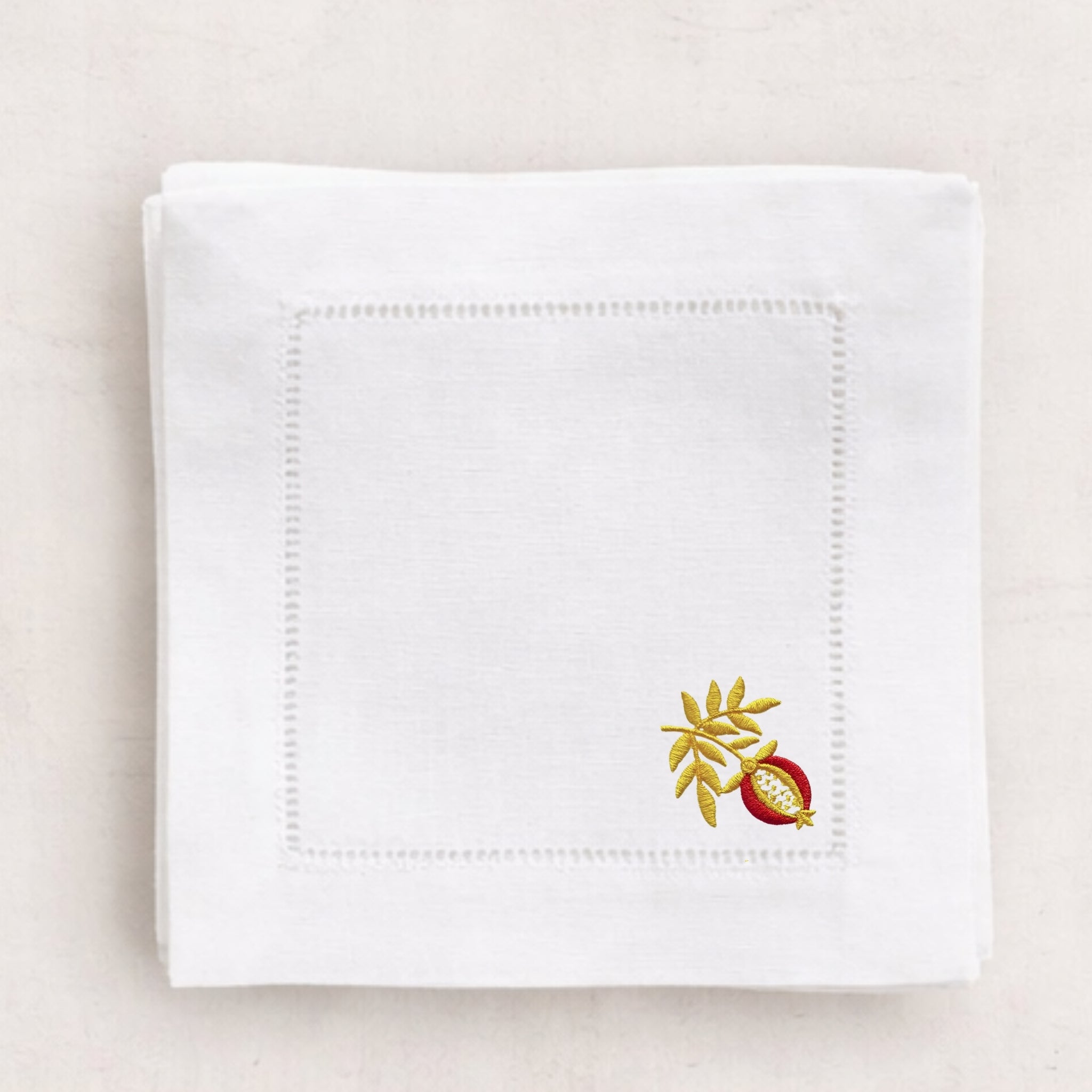 White napkin with embroidered design on a beige background