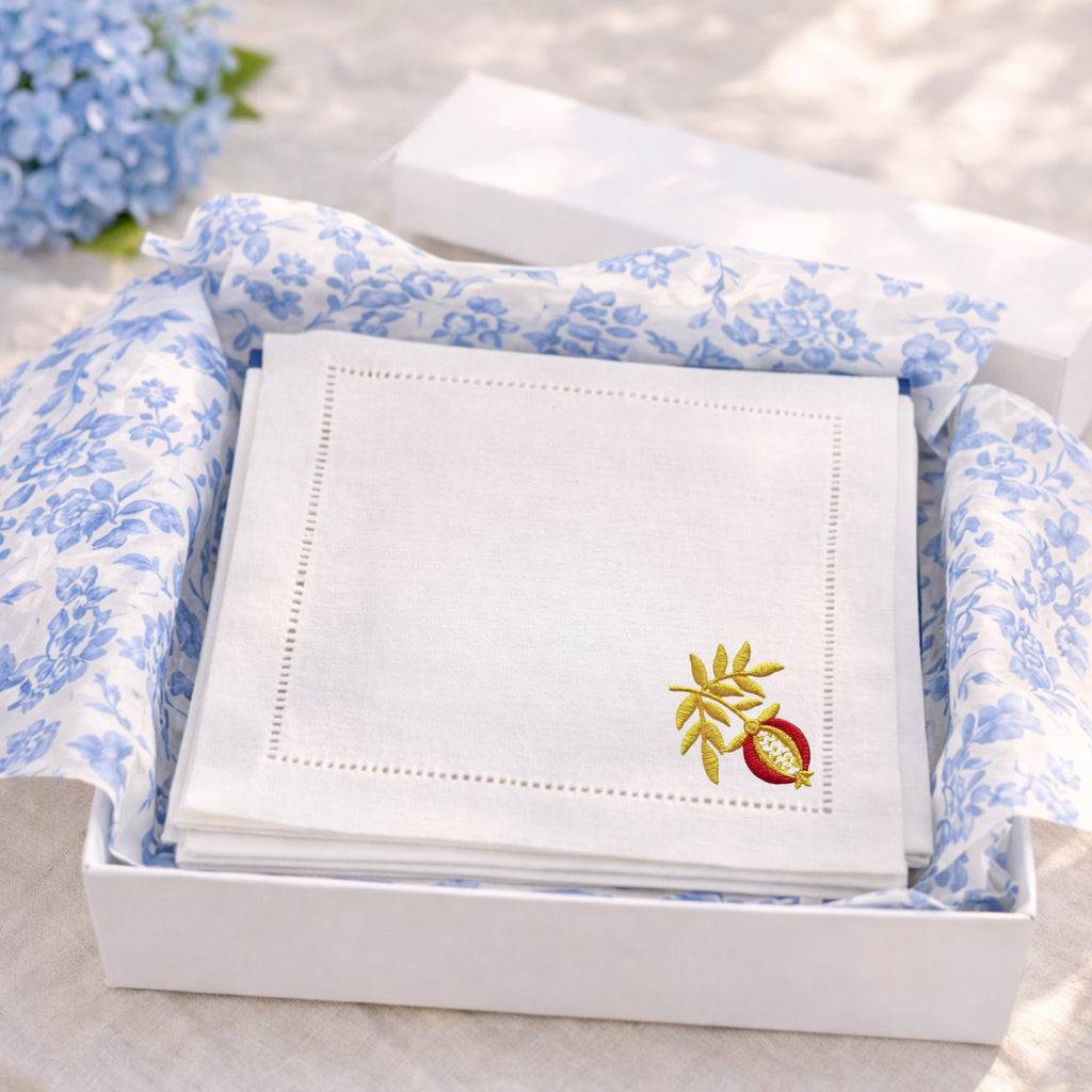Set of embroidered napkins in a box with floral tissue paper.