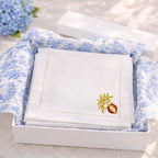 Set of embroidered napkins in a box with floral tissue paper.