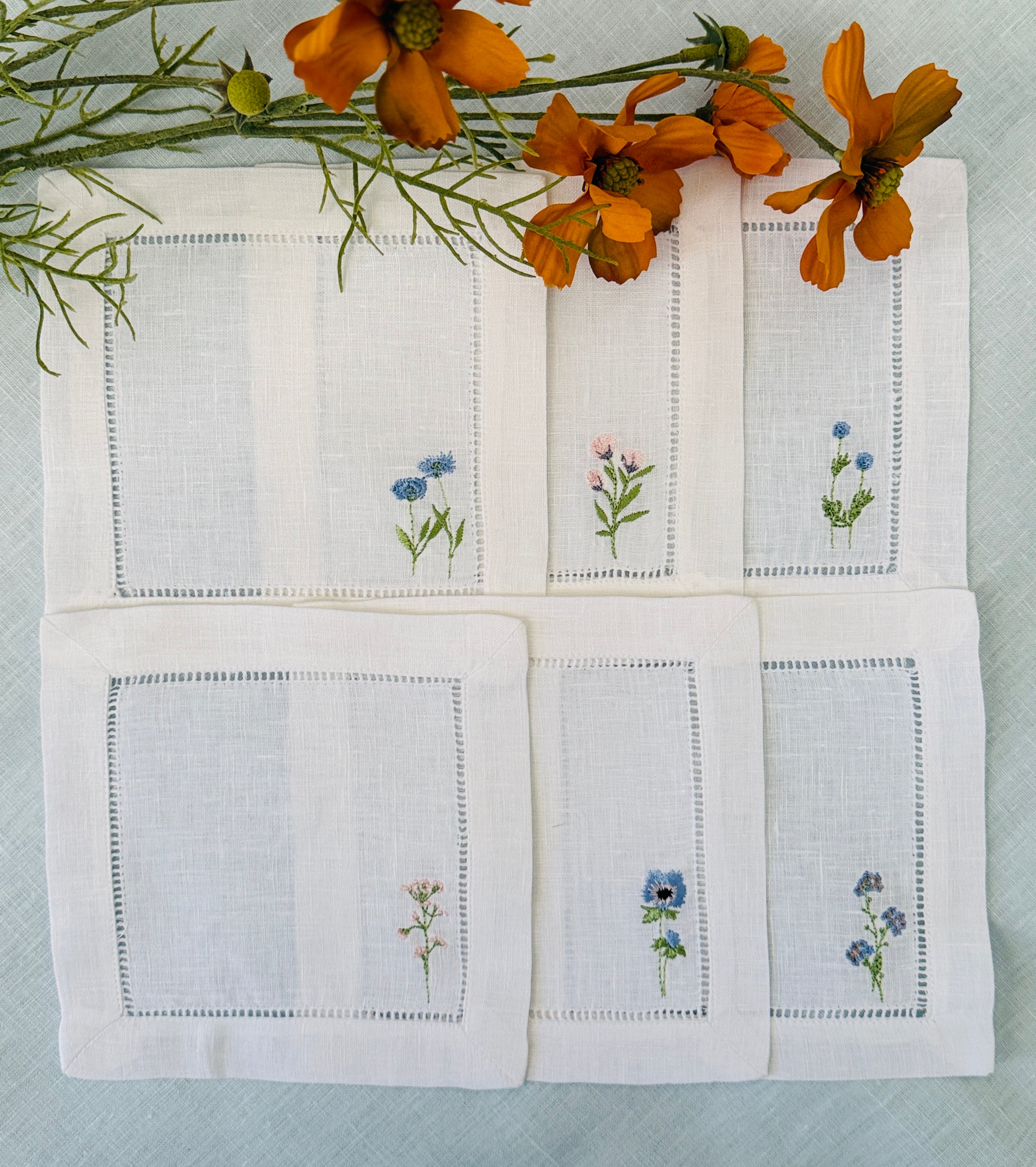 6 Linen Cocktail Napkins with 6 different Wildflowers stitched in blues and pinks.