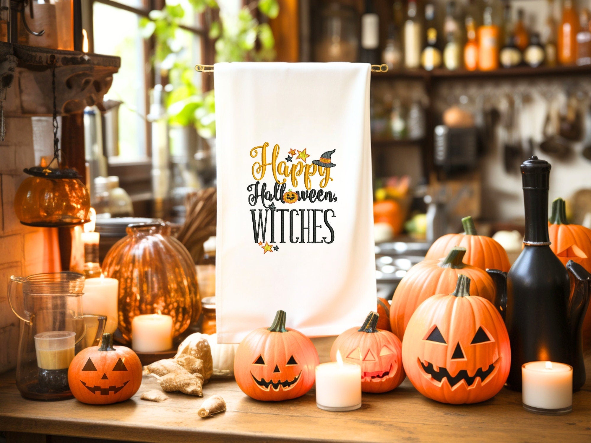 White tea towel on tea towel countertop holder amidst many pumpkins of different sizes as well as candles.