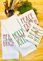 Set of 4 tea towels set on a cutting board stitched in red and green thread with Christmas greens, and copper measuring cups. The perfect gift for mom.