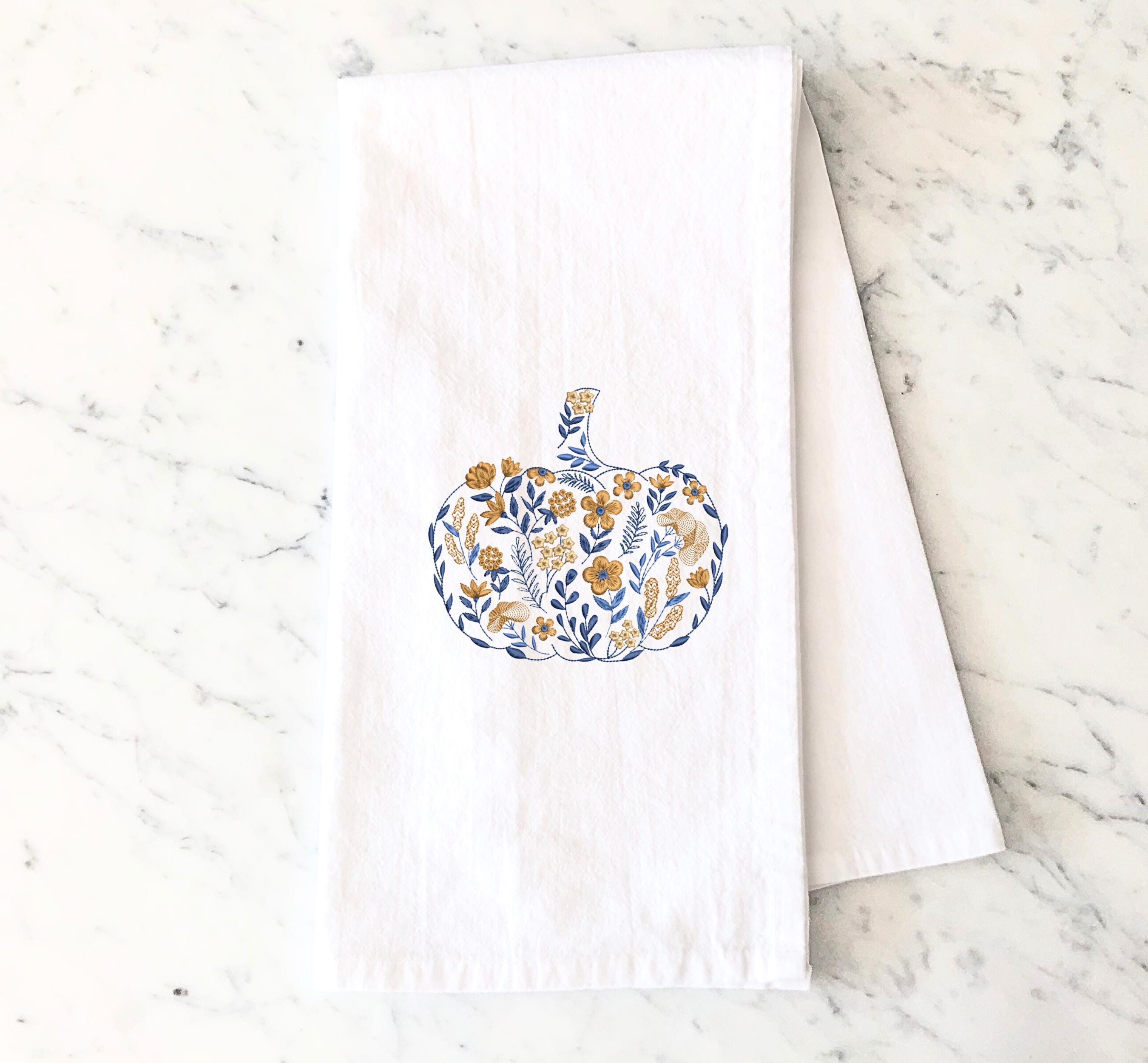 Blue and golden orange Embroidered Pumpkin, on top of a marble countertop  used for Fall Hosting Decor, Thanksgiving Towel, Hostess Gifts, for Your Best Friend.