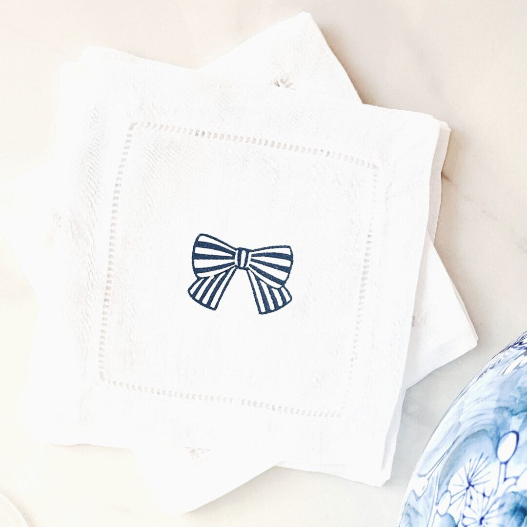 White linen napkin with a blue and white striped bow set on marble counter with blue and white vase. Perfect for 4th Anniversary gift.