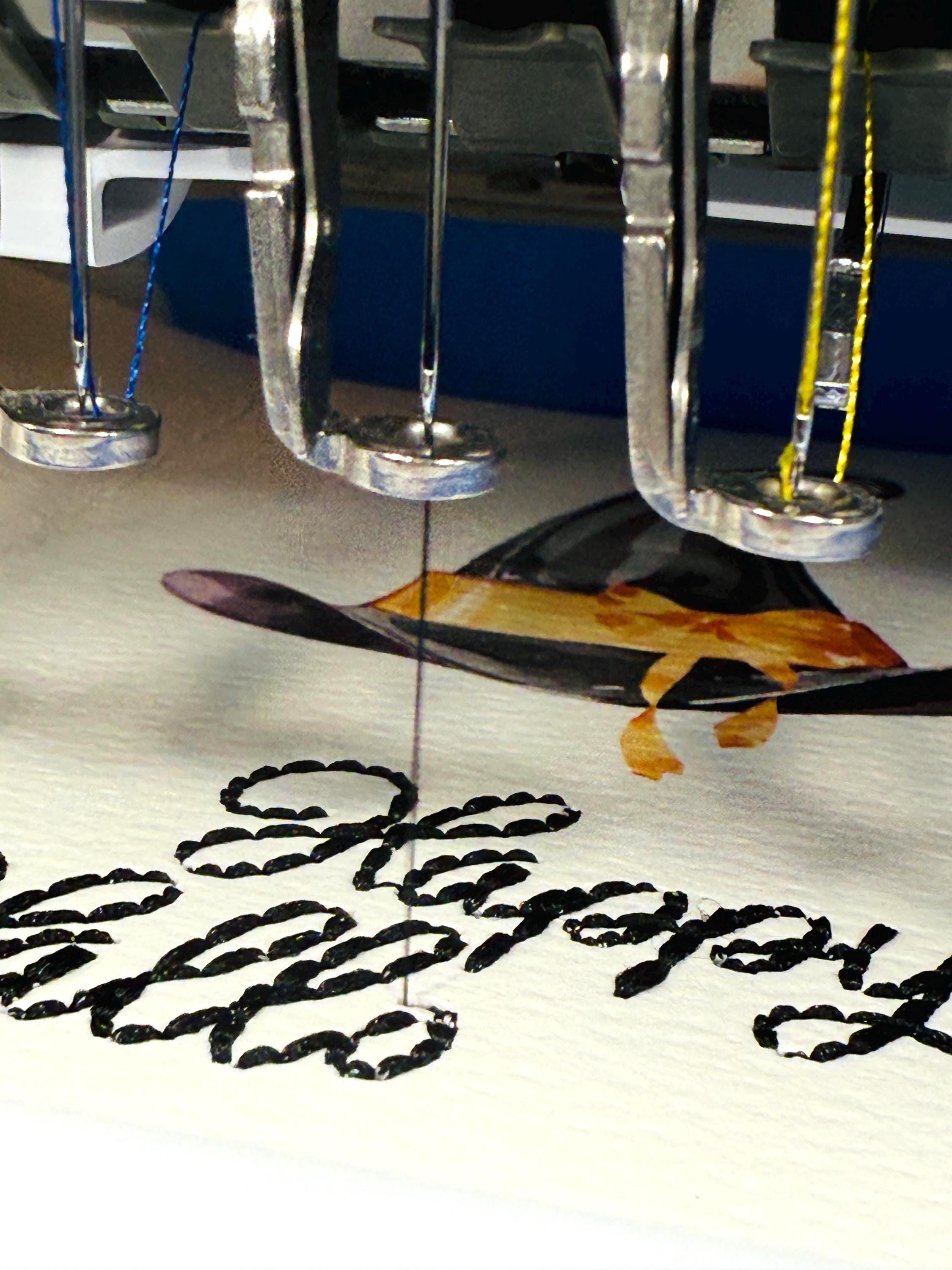 Happy Halloween being embroidered on the card.